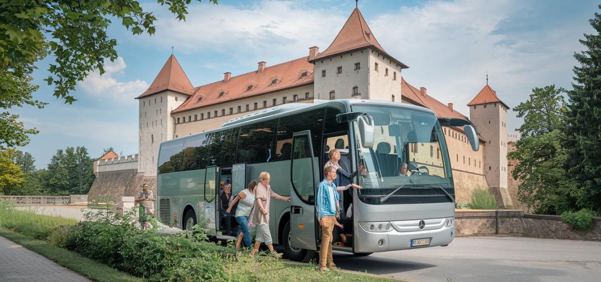 szürke buszra szállnak fel emberek, háttérben vár